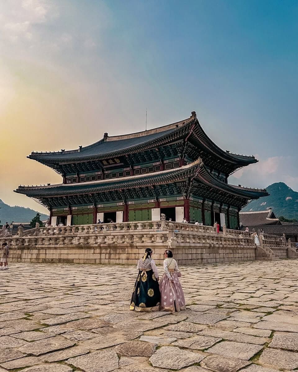Two visitors in hanbok in front of Gyeongbokgung Palace in Seoul