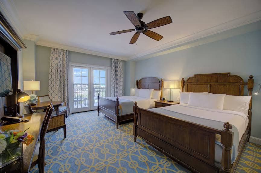 A resort hotel room with two beds and a balcony